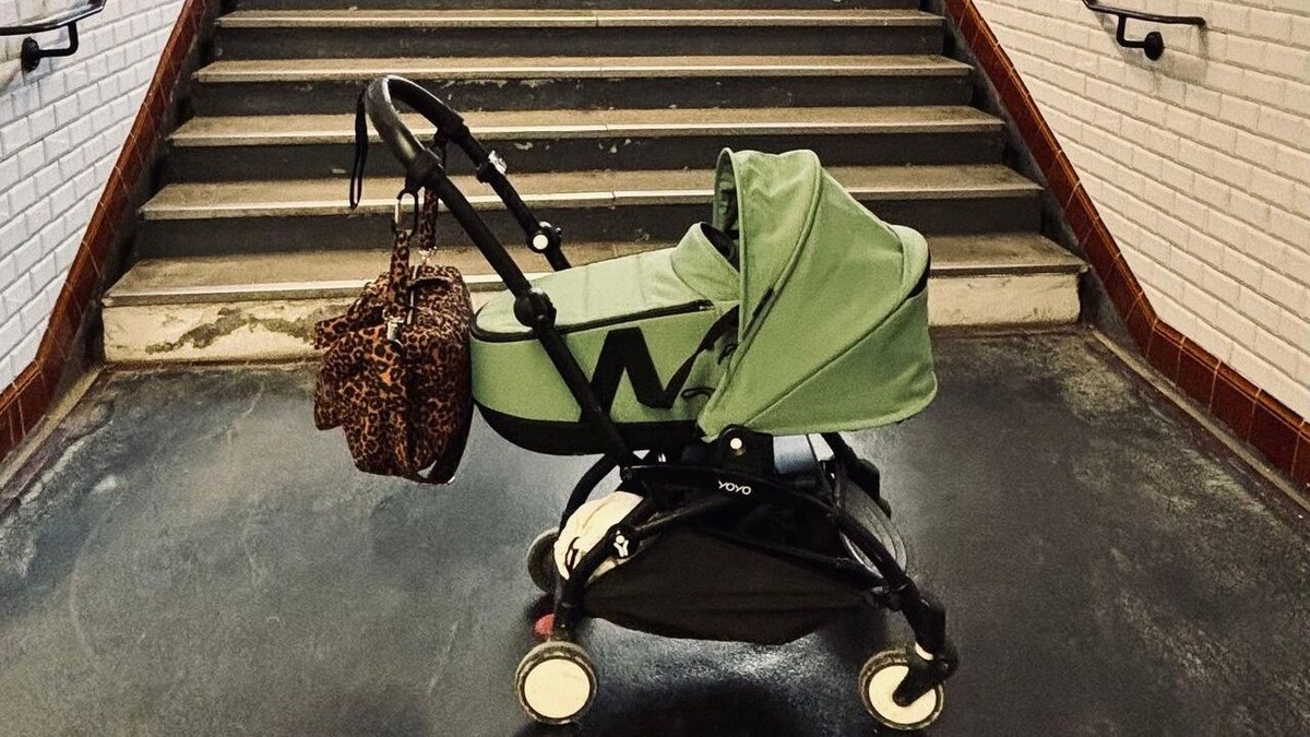 Un cărucior verde blocat la metrou în Paris, în fața scărilor