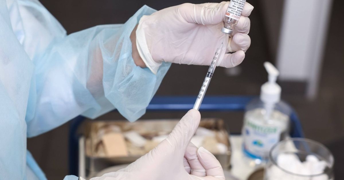 Asistent medical trage vaccin în seringă