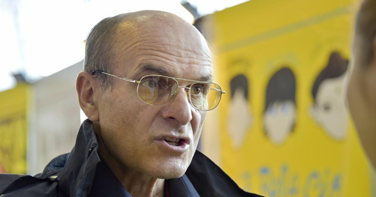 Cristian Tudor Popescu, având o grimasă în timp ce vorbește , îmbrăcat într-un palton negru și o cămașă bleumaren