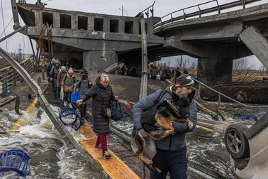 Oamenii din Irpin trec peste un pod distrus pentru a părăsi orașul | Foto: EPA