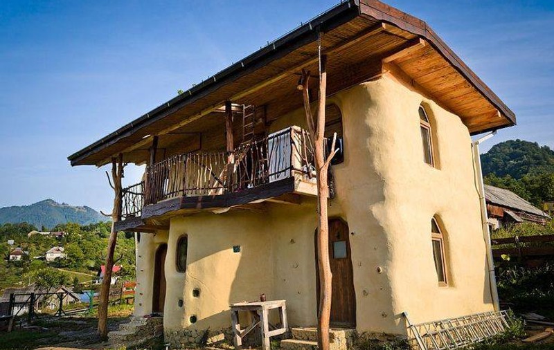 Și-au construit o casă din paie și pământ și vin în vacanță în inima Transilvaniei GALERIE FOTO