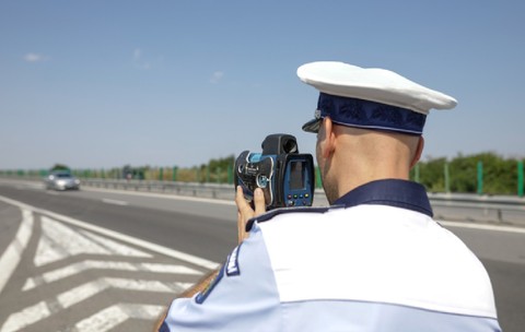 Autostrada 2 București - Constanța, România - 10 august 2021: Un agent al Poliției Rutiere din România folosește un radar de viteză.