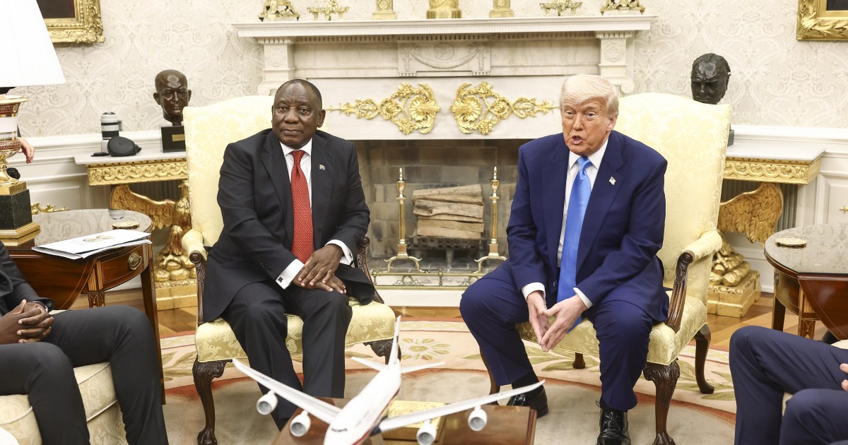 Donald Trump și Cyril Ramaphosa, președintele sud-african, în Biroul Oval. Cel din stânga este îmbrăcat cu un costum negru, cămașă albă și cravată roșie, Trump este îmbrăcat cu un costum bleumarin, cămașă albă și cravată bleu.
