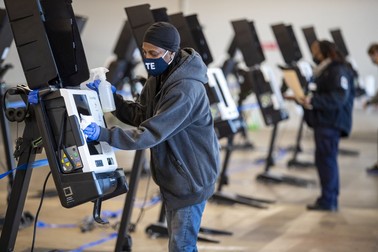 Un angajat dezinfectează o mașină de votare în Washington DC FOTO: EPA
