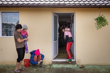 Mama Aurica şi fetiţele îşi lasă încălţările la intrarea în casă