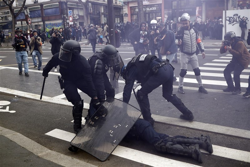 epaselect epa10538821 French police officers protect a colleague injured during clashes with protesters as thousands of people participate in a protest against the government's reform of the pension system in Paris, France, 23 March 2023. Protests continue in France after the prime minister announced on 16 March 2023 the use of Article 49 paragraph 3 (49.3) of the French Constitution to have the text on the controversial pension reform law - raising retirement age from 62 to 64 - be definitively adopted without a vote. EPA-EFE/YOAN VALAT