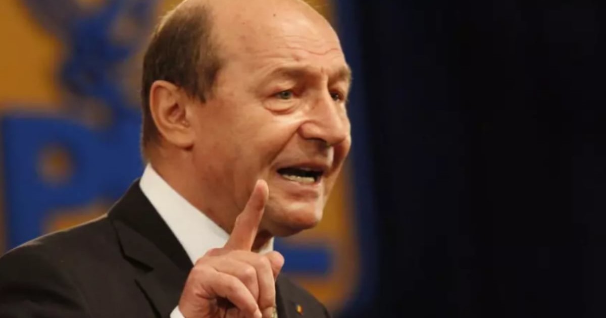 Traian Băsescu îmbrăcat în costum negru și cămașă albă.