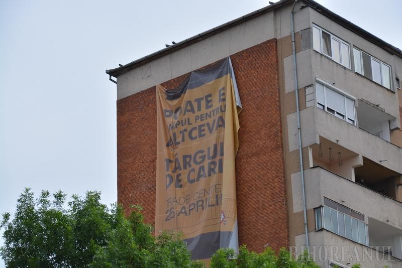 Blocul de pe care alpinistul utilitar din Oradea trebuie să coboare un banner publicitar