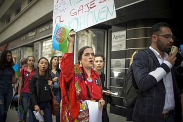 O femeie flutură drapelul oficial al etniei rome, în timpul unui marș de comemorare a Zilei Rezistenței Romilor, în București | Foto: Hepta