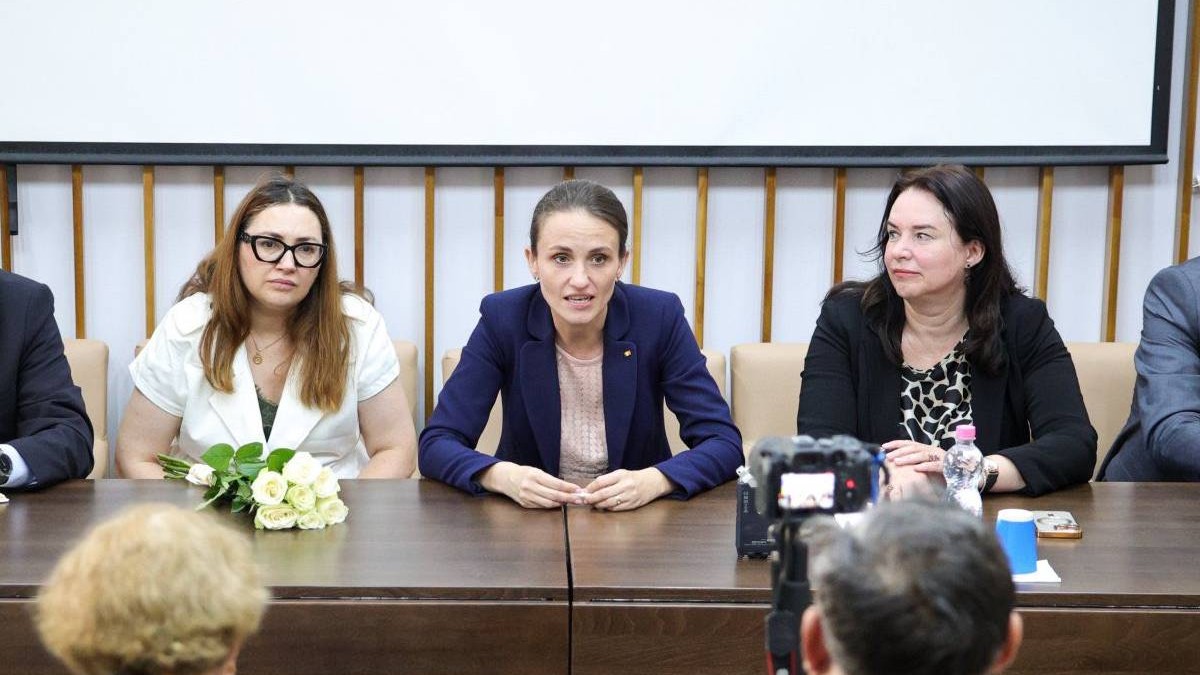 Oana Țoiu, ministrul Afacerilor Externe, în timpul unei conferințe de presă susținute în Ucraina, aceasta stă la masă și vorbește în fața jurnaliștilor