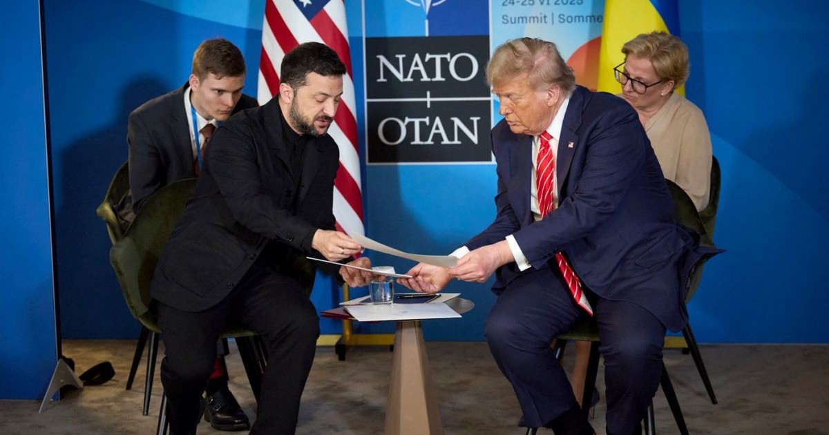 Volodimir Zelenski îi prezintă niște documente lui Donald Trump, în timp ce stau pe scaune la summitul NATo de la Haga, iunie 2025