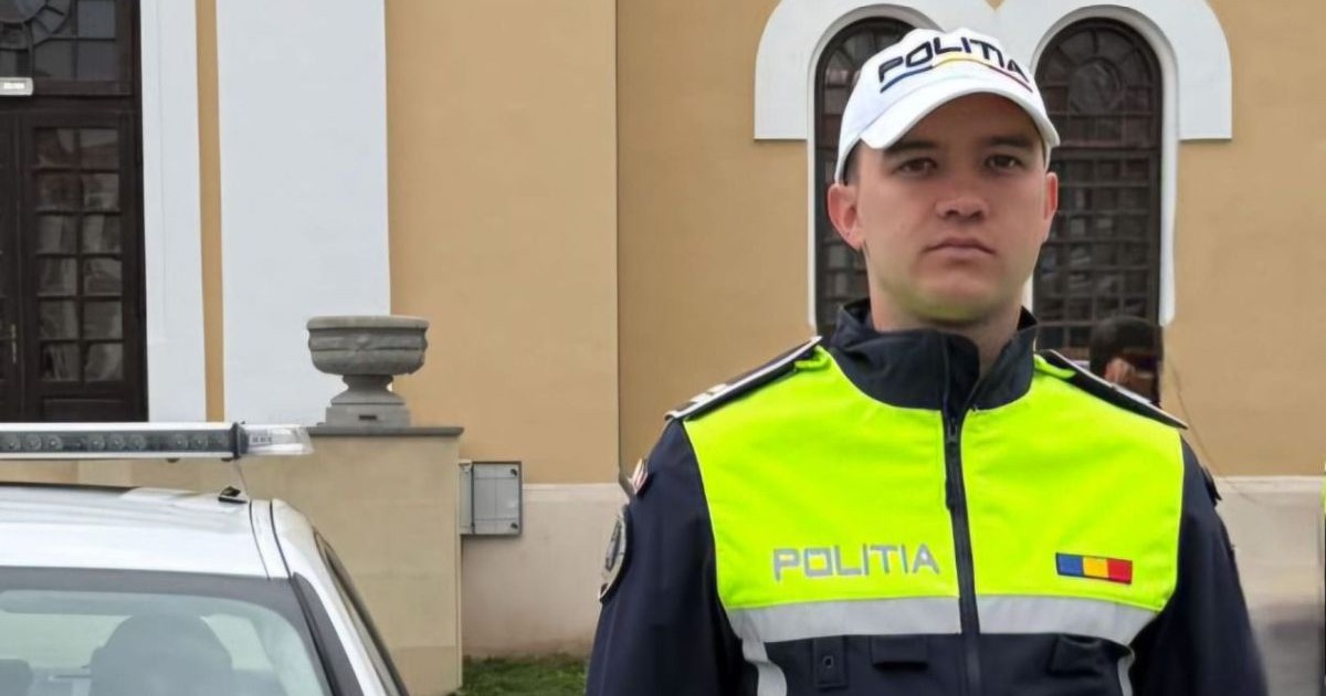 Polițistul Bogdan David din Alba, care a salvat o româncă de la înec în Creta, este fotografiat lângă mașina de poliție, în fața sediului IPJ Alba, august 2025