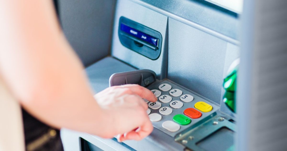 O femeie tastează pe un bancomat