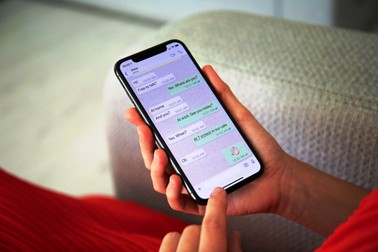 Woman holding iPhone X with social networking service WhatsApp