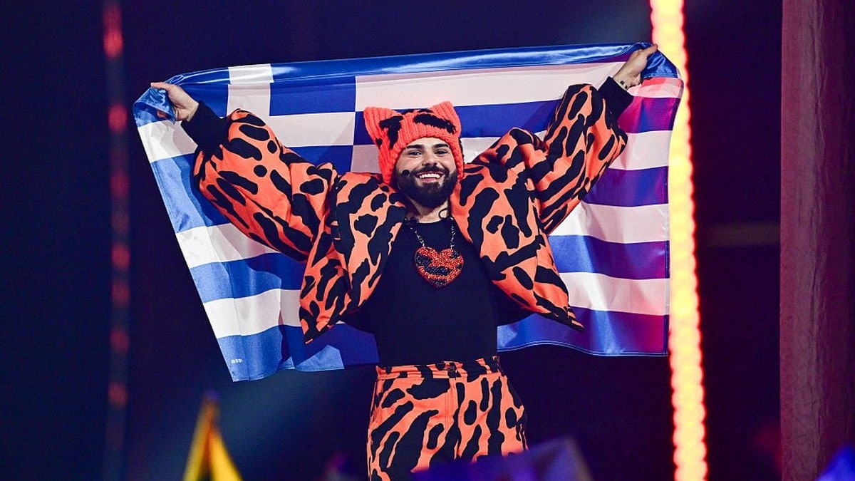 VIENNA, AUSTRIA - MAY 16: Akylas representing Greece walks into the grand final carrying the Greek flag during the Grand Final of the 70th Eurovision Song Contest at Wiener Stadthalle on May 16, 2026 in Vienna, Austria. (Photo by Christian Bruna/Getty Images)