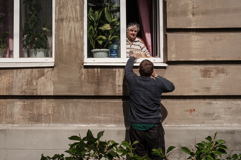 Un bărbat îi livrează pâini unei femei în orașul Lîman. Foto: Profimedia