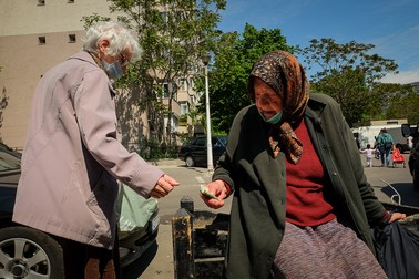 Unii trecători îi dau Eugeniei bani sau alimente