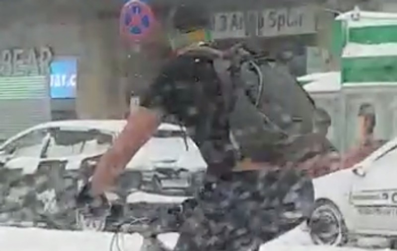 VIDEO/ Bărbatul care sfidează codul portocaliu de vreme rea. Se plimbă cu bicicleta în pantaloni scurți pe străzile din București