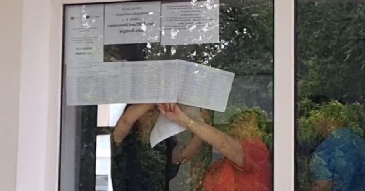 in imagine se vad trei persoane care lipesc pe frontul de sticla al unui liceu foi cu rezoltatele la bac 2025