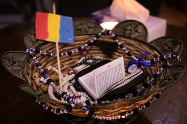 O cărticică cu fragmente din Coran și&nbsp; steagul României, într-un coș pe masa din sufragerie