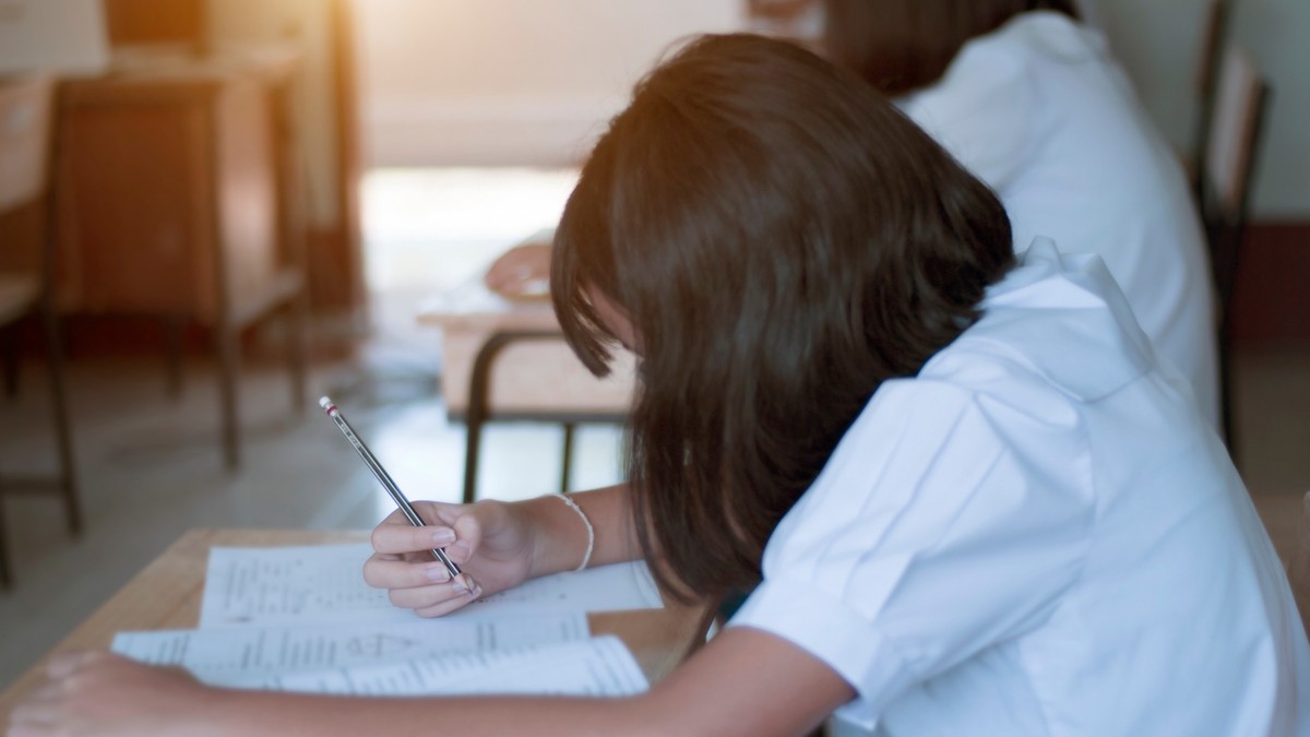 Rezultate Evaluare Națională 2024 - Imagine cu o elevă de gimnaziu care dă un examen