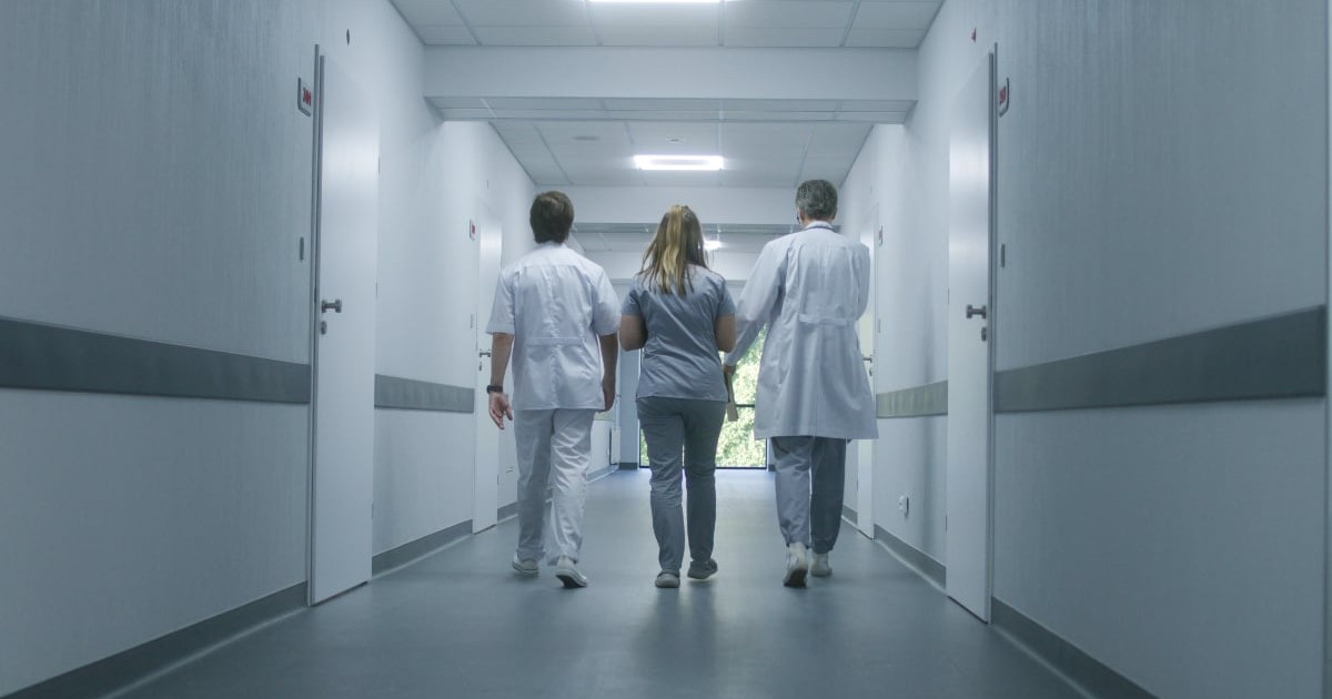 Doctori care merg pe holul unui spital.