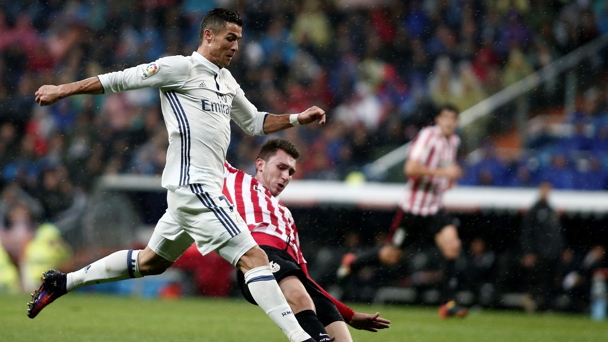 Cristiano Ronaldo (în alb) depăşeşte în alergare un adversar, în timpul meciului Real Madrid - Athletic Bilbao. (FOTO: HEPTA)