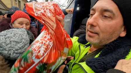 Petru oferind pungile de Crăciun oamenilor din zona Herson