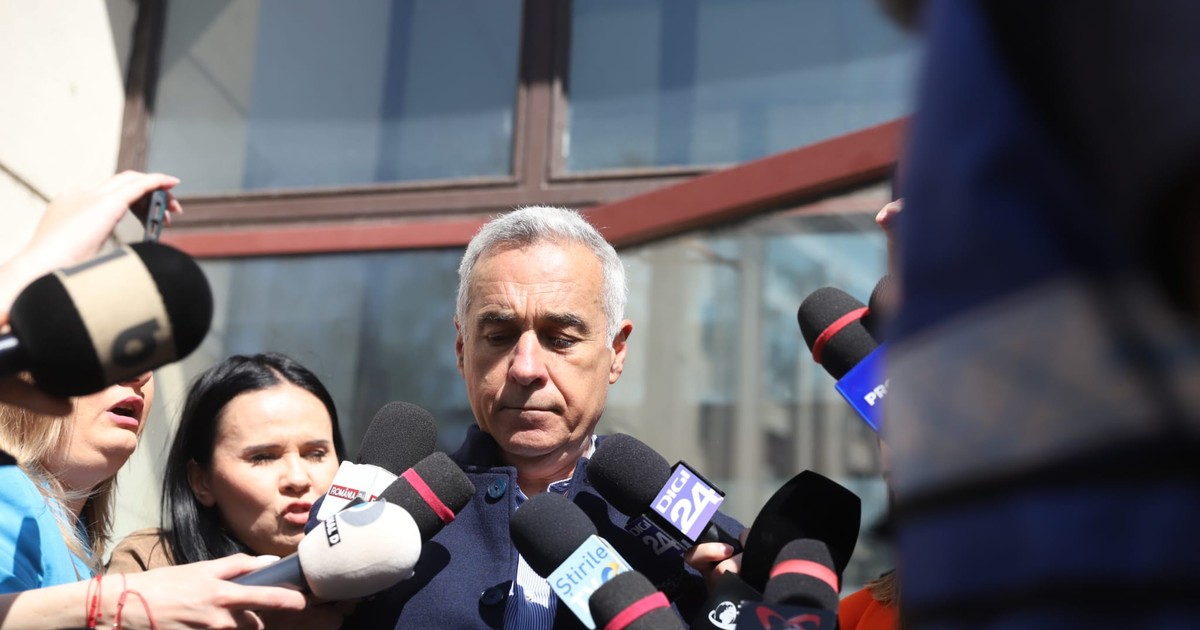 Călin Georgescu privește în jos, prezent la Judecătoria Sectorului 1, nu vrea să vorbească cu jurnaliștii, deși are microfoanele acestora în apropiere.