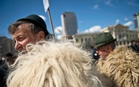 Grup de ciobani purtând cojoace din blană de oaie și pălării verzi în timpul unei manifestații de protest