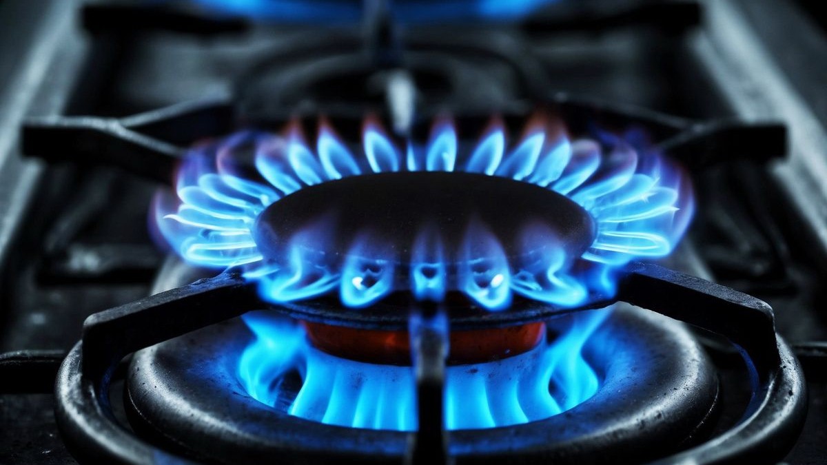 Flăcări albastre de gaz care ard la un aragaz într-o bucătărie