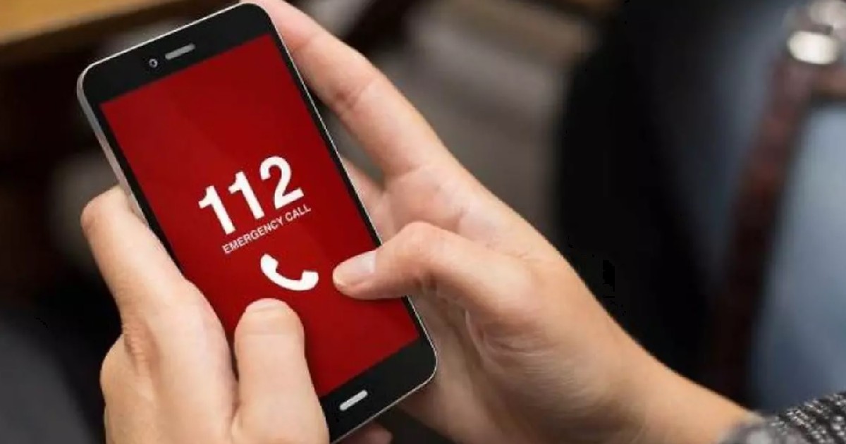 Un bărbat apelează 112 pe un telefon mobil