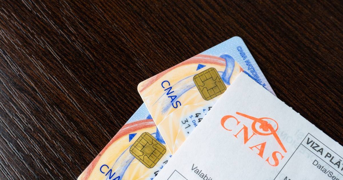 doua carduri de sanatate cnas pe un birou, deasupra un bilet de trimitere cnas