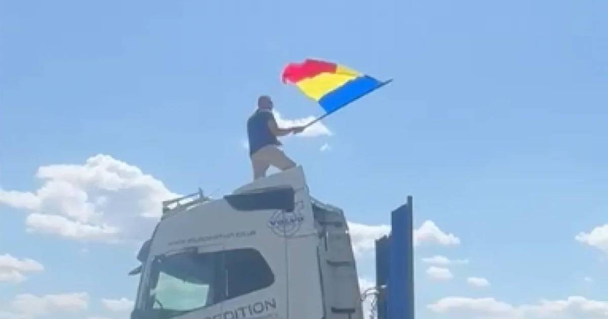 Șoferul de TIR de 33 de ani, urcat pe cabina autotrenului care bloca intrarea în București, în timp ce flutură drapelul României