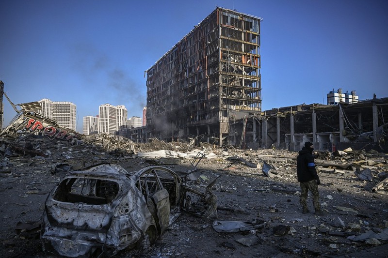Un militar ucrainean se plimbă printre dărâmături în afara mall-ului Retroville, distrus în urma unui atac al forțelor ruse asupra capitalei ucrainene Kiev, pe 21 martie 2022. Cel puțin opt persoane au fost ucise în bombardamentul din timpul nopții | Foto: Profimedia Images