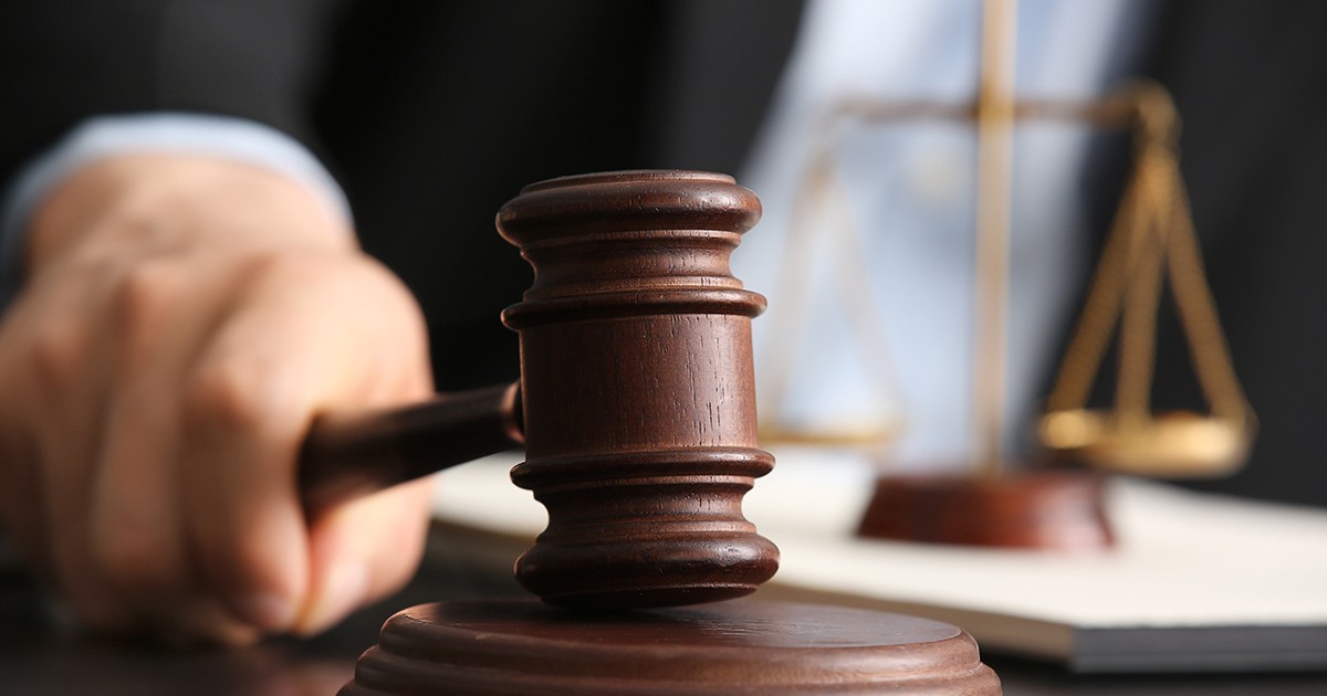 Judecător bărbat cu ciocan la masă în sala de judecată