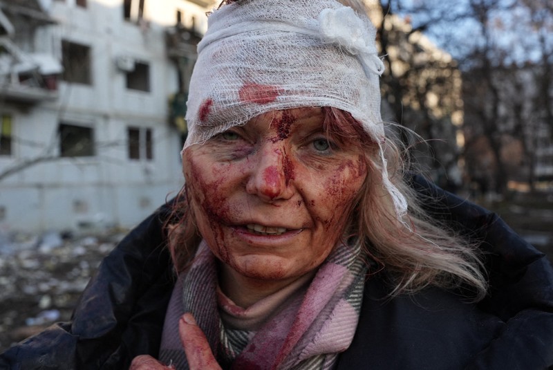 O femeie rănită este văzută în timp ce un atac aerian distruge un complex de apartamente în afara orașului Kharkiv, Ucraina, pe 24 februarie 2022.