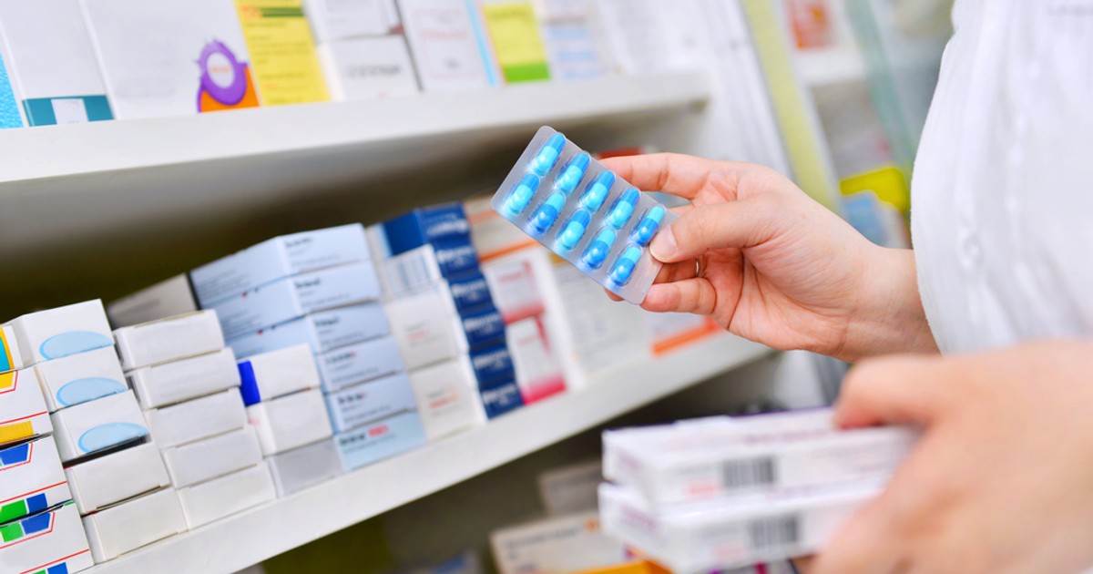 Lista medicamentelor cu care sunt tratați românii diagnosticați cu coronavirus. Farmacie - imagine cu un farmacist ce selecteaza medicamente de pe rafturi