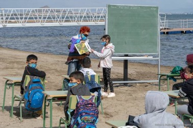 Elevi și profesoara lor, în timpul unei ore ținute pe plajă