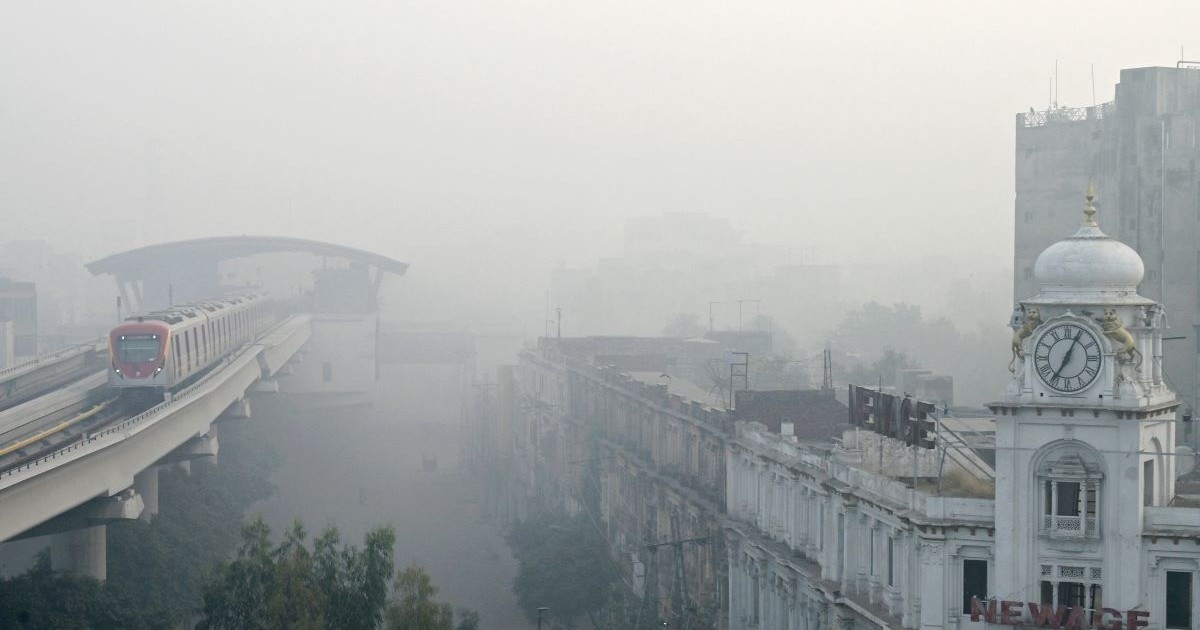 Un tren de metrou pe linia portocalie (OLMT) este fotografiat pe o linie înălțată, în mijlocul condițiilor de smog din Lahore, pe 3 noiembrie 2024
