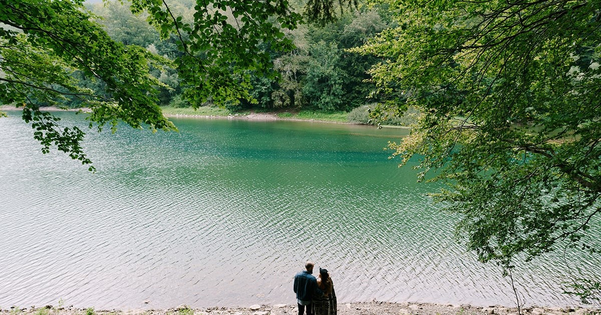 Un cuplu în fața unui lac.