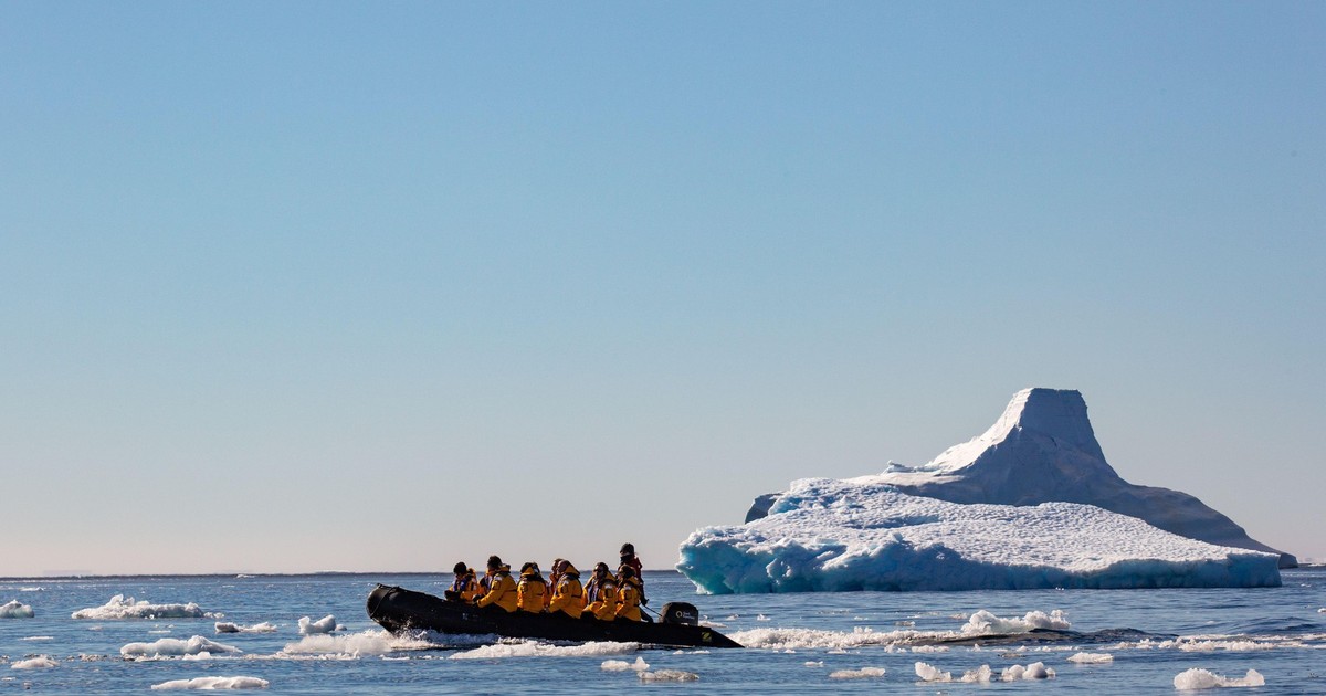 Imagine cu o barcă plină de turiști în Antarctica