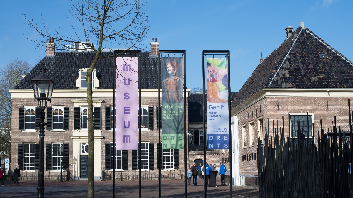 Exteriorul Muzeul Drents din Assen, unde erau expuse artefactele dacice, surprins într-o zi senină, cu bannerele expoziției la intrare. Imaginea oferă un cadru sobru și calm, în contrast cu jaful spectaculos care a avut loc aici în urmă cu un an.