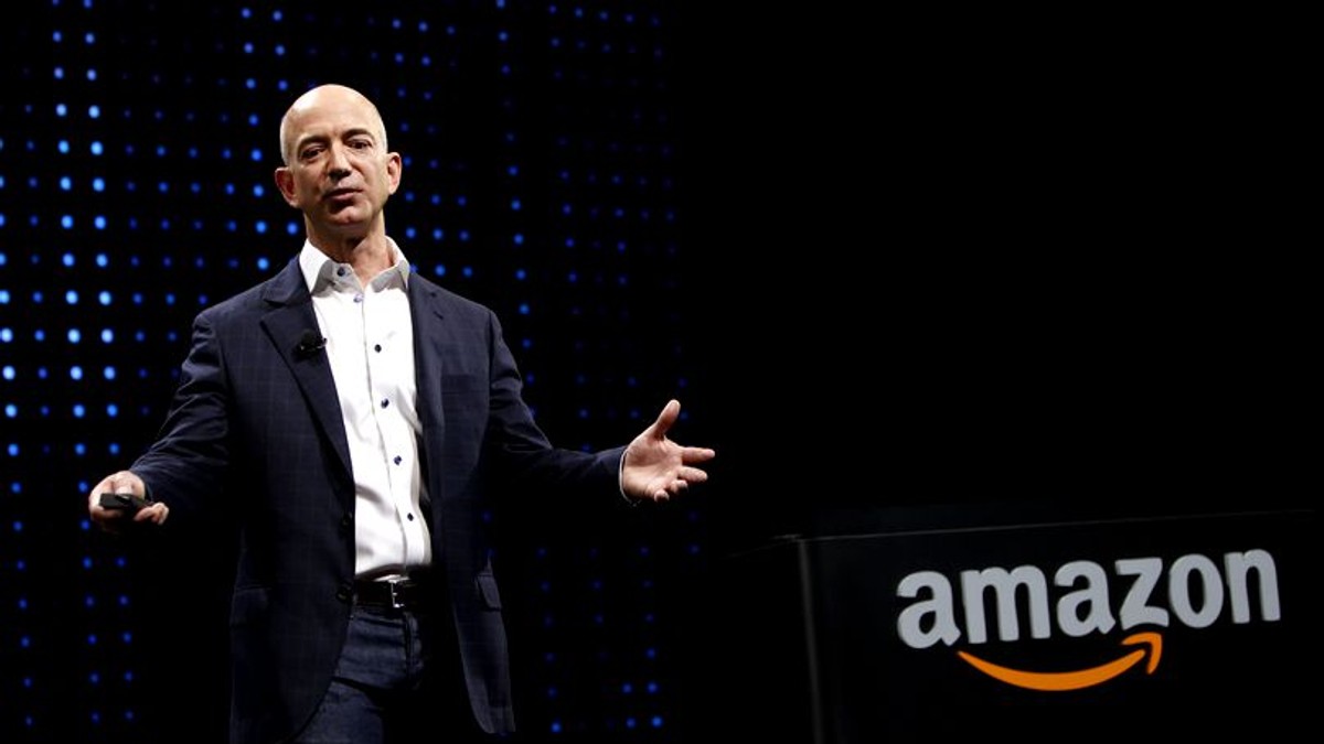 Jeff Bezos e acum de două ori mai bogat decât Mark Zuckerberg. Bezos pe o scenă, cu logo-ul Amazon în spate