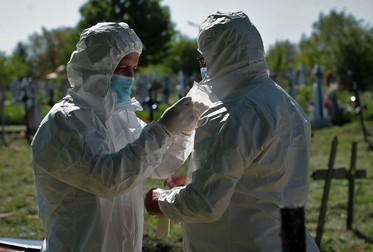 Groparii se echipează pentru a înmormânta o victimă Covid