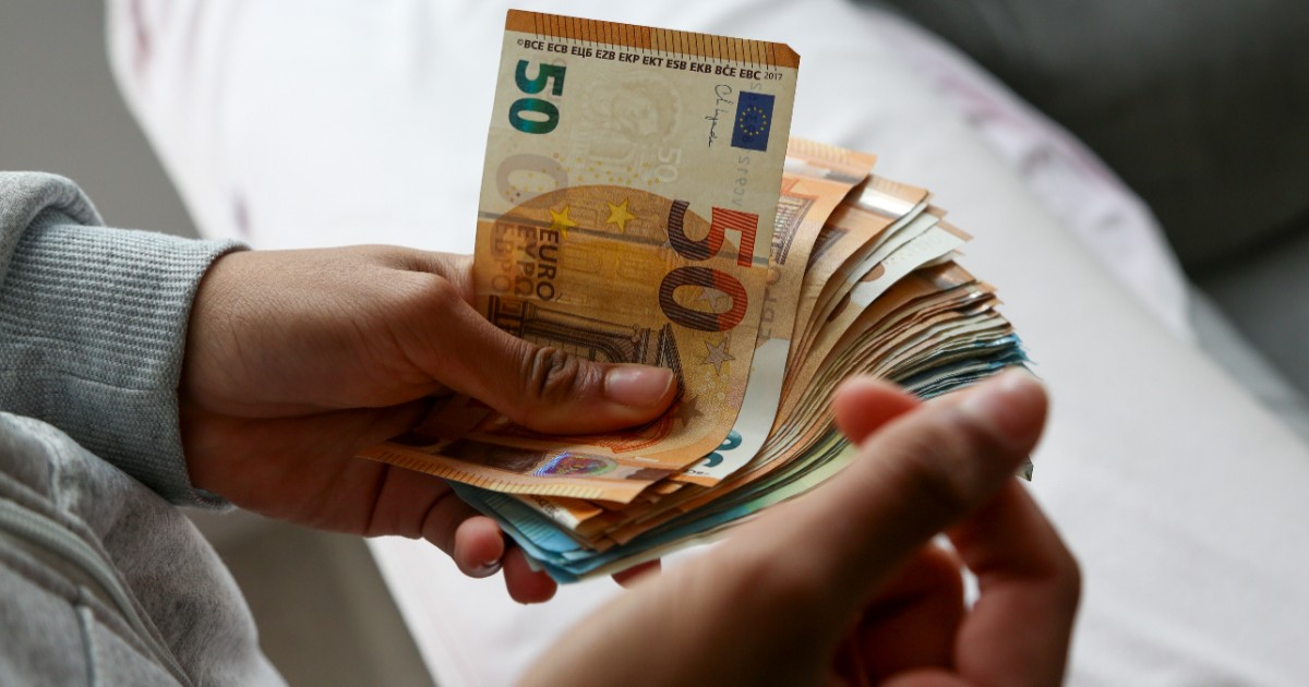 O femeie care ține bancnote de euro în mâini