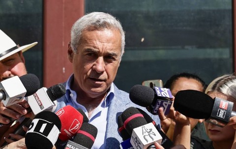 Călin Georgescu vorbește cu jurnaliștii la ieșirea din Parchet. e îmbrăcat cu un costum și are o figură gravă