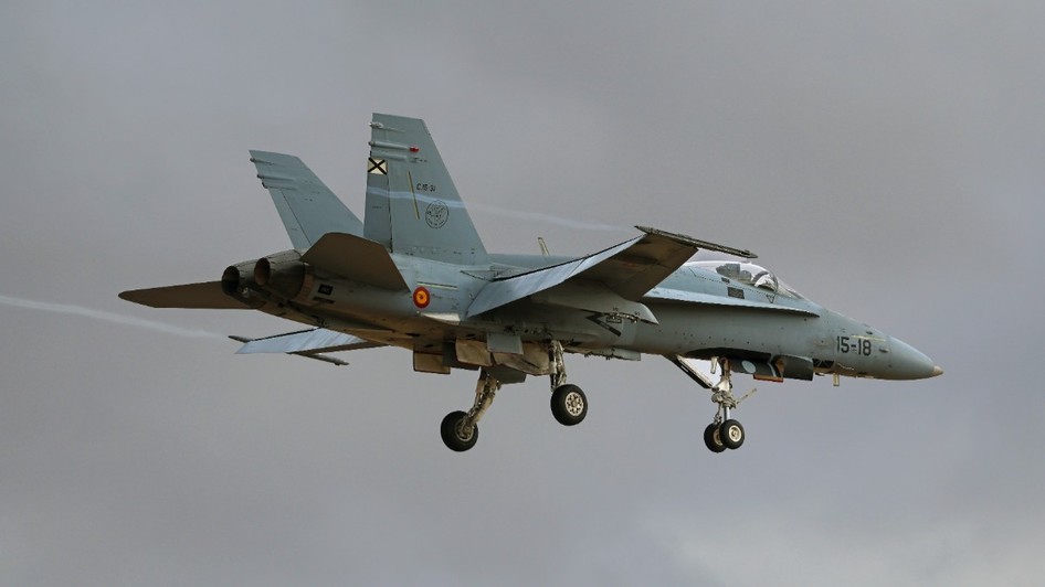 Un avion de vânătoare F/A-18 Hornet aflat în zbor la altitudine joasă, cu trenul de aterizare coborât