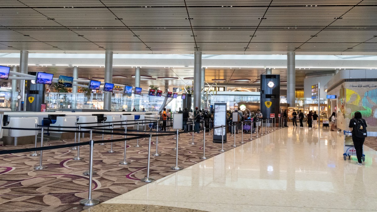Oameni care stau la coada in aeroport