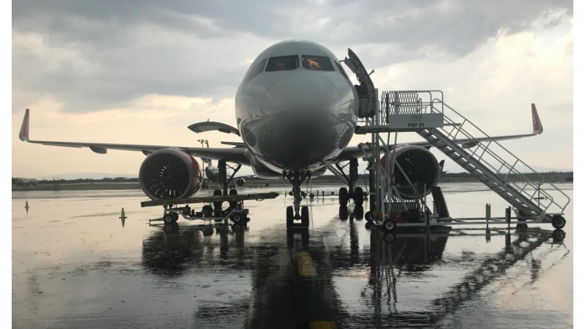 Flyrefund - poza cu un avion alb aflat in aeroport, pe loc.